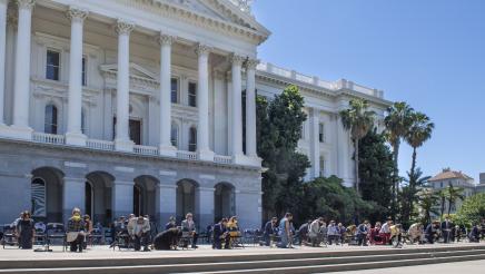 Assemblymembers kneeling outside the state capitol in a tribute to George Floyd