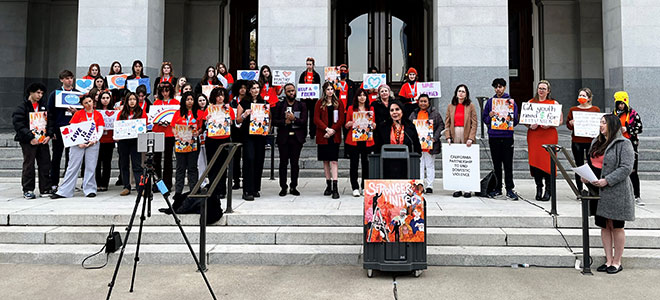 Group of teenagers standing in front of the CA state capitol for National Teen Dating Violence Awareness Month