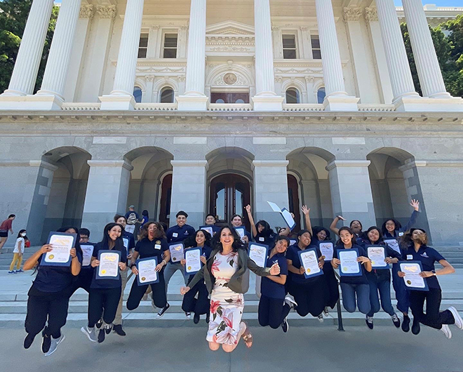 Assemblywoman Rubio and a group of students jumping in the air holding their Young Legislators certificates